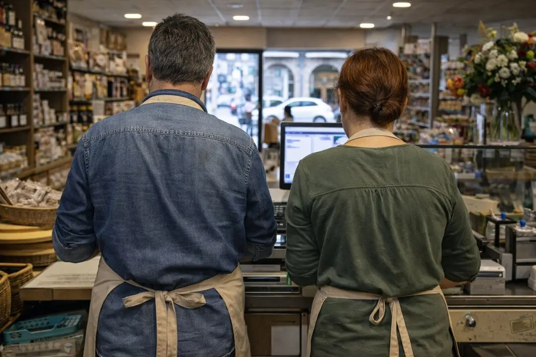 Dos dependientes trabajan en el mostrador de su tienda mientras revisan la actividad diaria, reflejo de la presi&oacute;n econ&oacute;mica que afrontan muchos peque&ntilde;os negocios.