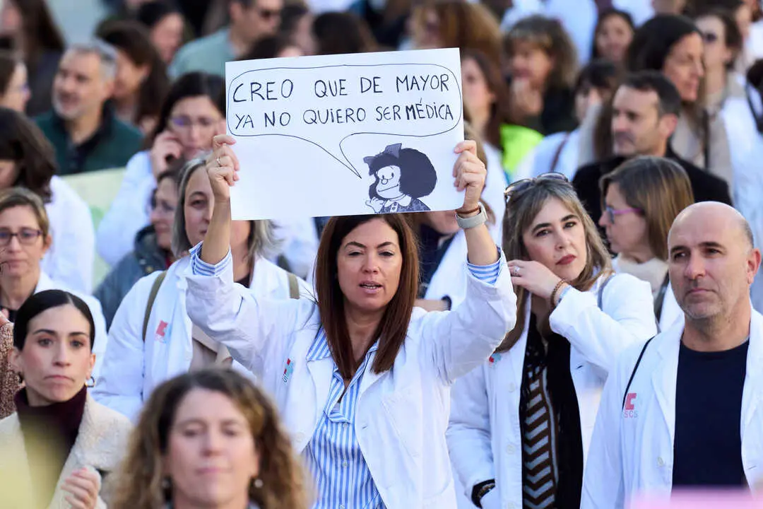 Una mujer, vestida con bata m&eacute;dica, sostiene un cartel durante una concentraci&oacute;n de sanitarios. En el mensaje puede leerse: &ldquo;Creo que de mayor ya no quiero ser m&eacute;dica&rdquo;, acompa&ntilde;ado de una ilustraci&oacute;n, reflejando el malestar del colectivo. A su alrededor, decenas de profesionales de la salud participan en la protesta, evidenciando el clima de reivindicaci&oacute;n en el sector sanitario. Juanma Serrano - Europa Press - Archivo