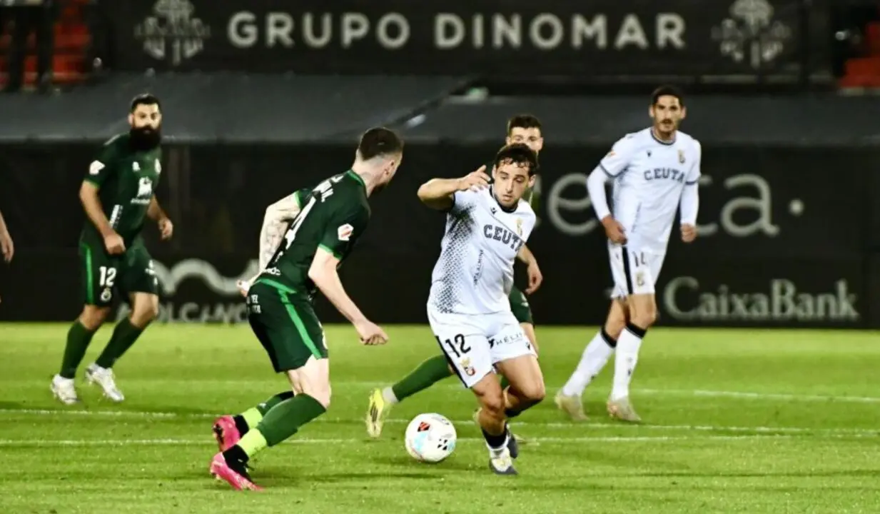 Jugadores del Racing y del Ceuta disputan un bal&oacute;n durante el partido en el Alfonso Murube, marcado por la pol&eacute;mica tras los tres goles anulados al conjunto c&aacute;ntabro.