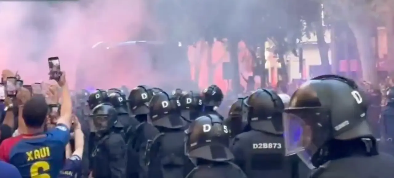 Aficionados del Barcelona reciben al equipo azulgrana en los alrededores del Camp Nou antes del cl&aacute;sico, en unos accesos marcados por el lanzamiento de objetos y los incidentes con los autobuses de ambos equipos.