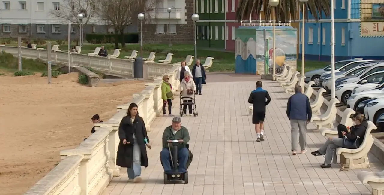Vecinos pasean por el entorno mar&iacute;timo de Laredo en una jornada tranquila junto a la playa de la villa c&aacute;ntabra. / RTVE