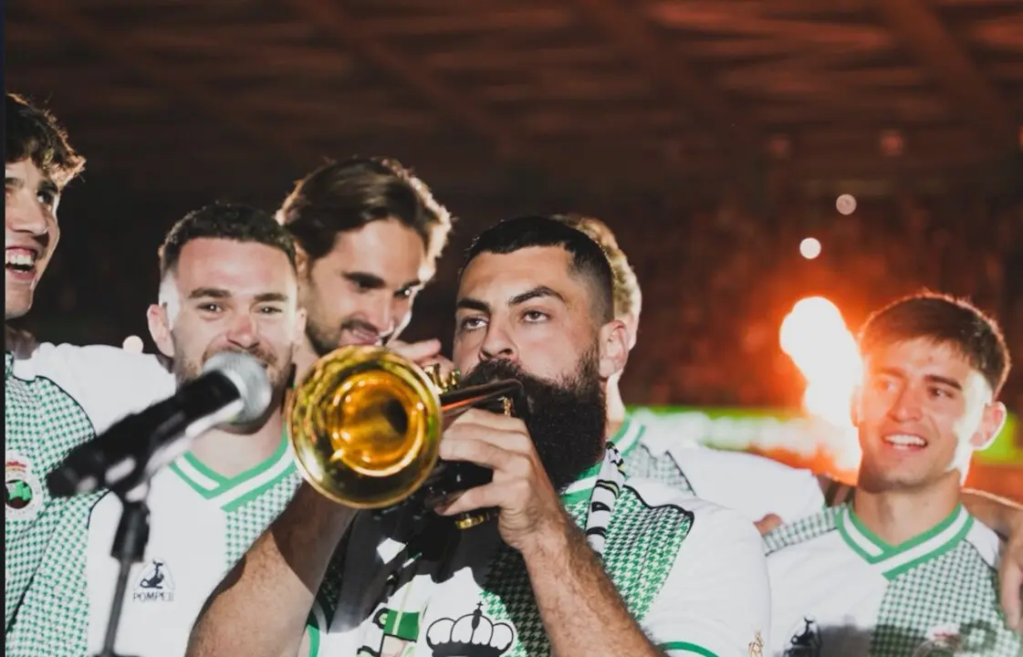 'El Bufalo' del Racing toca la trompeta durante la fiesta del ascenso mientras sus compa&ntilde;eros corean canciones junto a miles de racinguistas en El Sardinero.