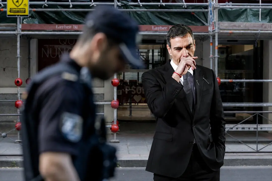 Composici&oacute;n IA. Sanchez, un policia nacional durante el registro en la sede del PSOE. / IA