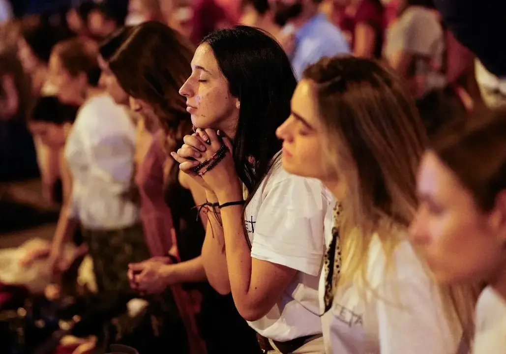 J&oacute;venes participan en un momento de oraci&oacute;n y recogimiento durante la vigilia presidida por el papa Le&oacute;n XIV en Madrid, ante cientos de miles de asistentes congregados en la Plaza de Lima y el Paseo de la Castellana.