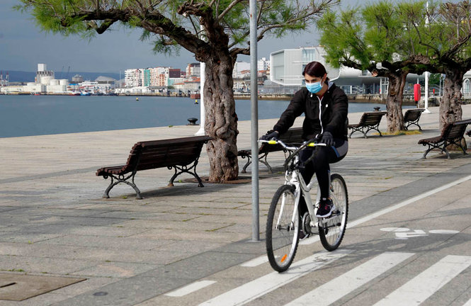 Una persona anda en bicicleta por en Santander, protegido con su mascarilla. / J. RAMÓN
