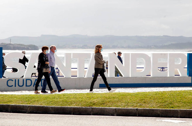 Varias personas camina frente al cartel &#39;Santander&#39; en el Sardinero. / J.RAMÓN