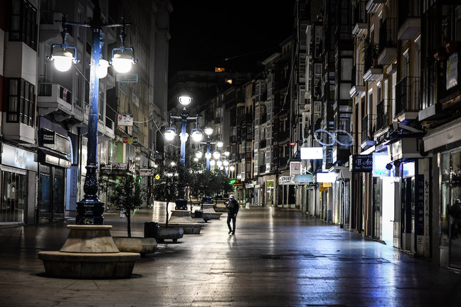 Una persona camina en la calle Burgos de Santander tras el toque de queda. / HARDy