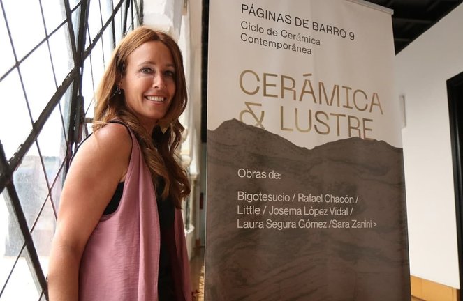 Marián Aguilar con el cartel de la exposición 'Cerámica & Lustre', título elegido para la 9ª edición del proyecto 'Páginas de Barro'.