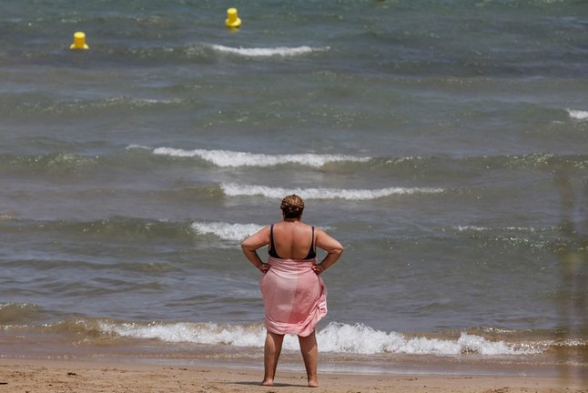Una mujer en la Playa de la Malvarrosa en un día de alerta roja por altas temperaturas, a 12 de julio de 2021, en Valencia, Comunidad Valenciana (España). Las provincias de Alicante, Valencia y Murcia tienen este lunes avisos de nivel rojo (riesgo extremo