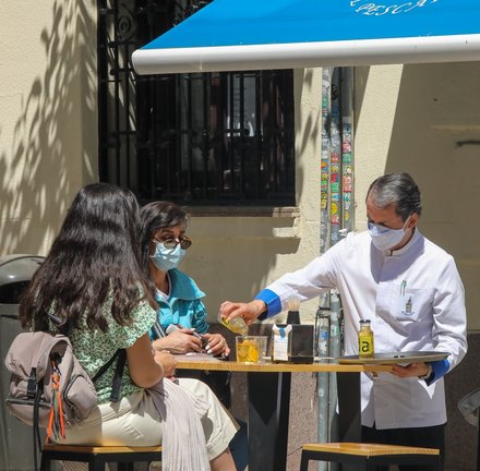 Archivo - Un camarero sirve un refresco a dos personas en una terraza, a 7 de mayo de 2021, en Madrid (España).