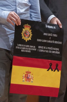 Un familiar de uno de los dos policías caídos en un atentado terrorista en la Embajada de España en Afganistán en 2015, sostiene una bandera de España que había sido custodiada en el país para recordarlos