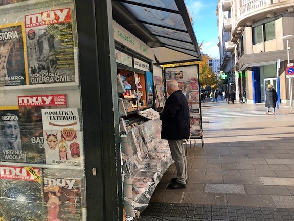 Una persona sin mascarilla compra algo de leer en un kiosko de Santander. / ALERTA