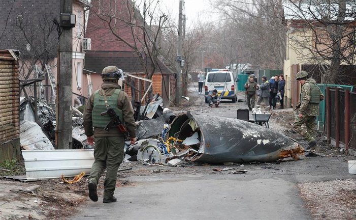 Soldados observan los restos de un avión militar derribado durante la noche en Kiev, Ucrania, el 25 de febrero de 2022. Las tropas rusas entraron en Ucrania el 24 de febrero, lo que llevó al presidente del país a declarar la ley marcial. (Rusia, Ucrania) EFE/EPA/SERGEY DOLZHENKO