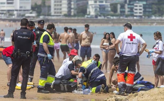 Los socorristas de la Cruz Roja tratan de reanimar a la mujer fallecida en la playa. / POLICÍA LOCAL