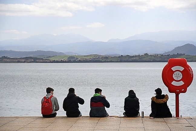 Varios jóvenes sentados frente a la bahía de Santander. / ALERTA