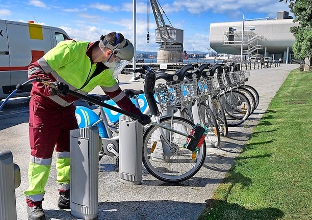 Un empleado limpia unas bicicletas del servicio de alquiler de Santander. / alerta
