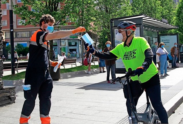 Un ciclista recibe una mascarilla en Santander. / JOSÉ RAMÓN