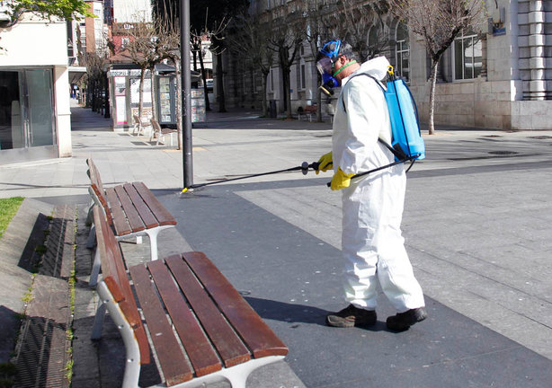 Un operario trabaja para desinfectar el mobiliario urbano. / J. RAMÓN