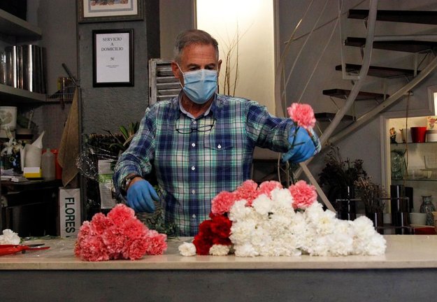 Un dependiente en una floristería de Santander prepara un ramo de flores. / J. Ramón