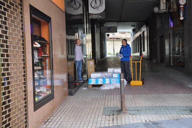Un repartidor descarga el material para un comercio en la calle Joaquín Cayón de Torrelavega. / S.D.