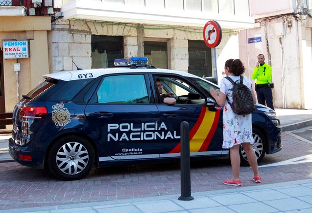 La Policía nacional atiende a una ciudadana a la vista de un policía local en Santander.