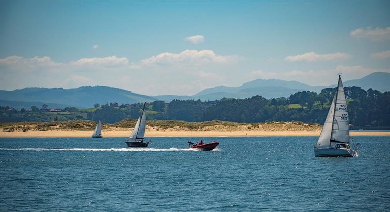 Vista general de las embarcaciones de recreo navegando, hoy domingo, en la bahía de de Santander, con la playa del Puntal y el Real Golf de Pedreña.-EFE/ROMÁN G. AGUILERA