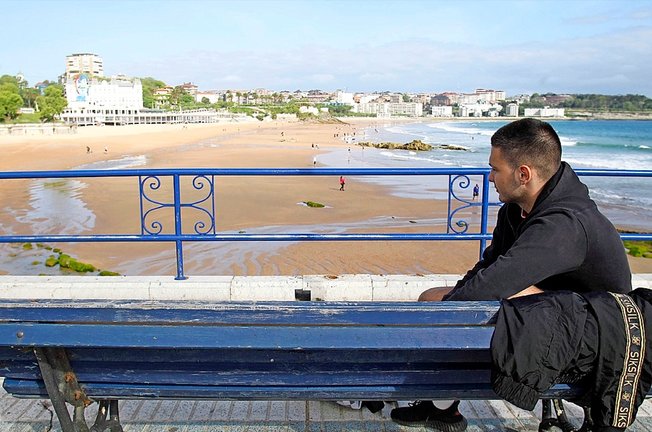 Una persona descansa en un banco junto a la playa del Sardinero, Santander. / J. Ramón