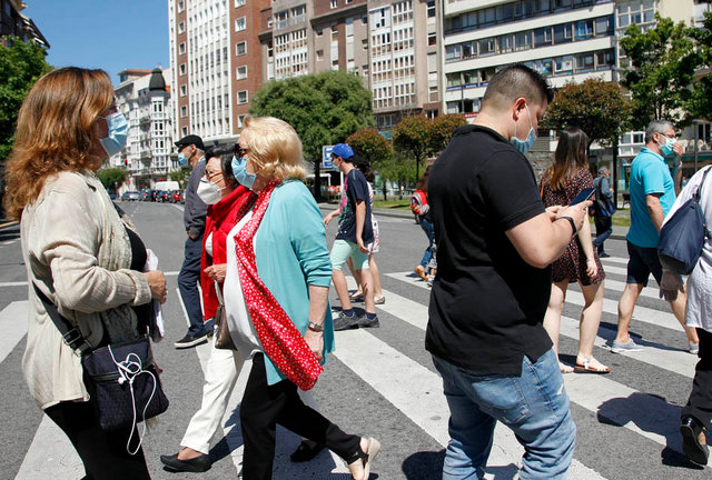 Varias personas pasan un paso de cebra con sus mascarillas puestas en la ciudad de Santander. / J. Ramón