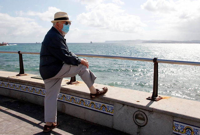 Una persona con mascarilla disfruta de las vistas al mar en Santander. / J. Ramón