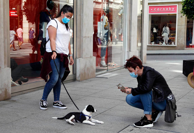 Dos personas realizan una foto a un perro en la ciudad de Santander. / J. Ramón