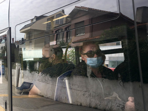 Dos personas sentadas en el autobús de Santander con su respectiva mascarilla. / S.D.