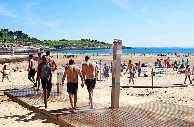 Varias personas disfrutan en la segunda playa del Sardinero en Santander.