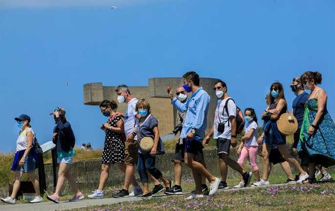 Un grupo de turistas visita este domingo el Elogio del Horizonte, una escultura de hormigón del escultor vasco Eduardo Chillida situada en Gijón. EFE/ Alberto Morante
