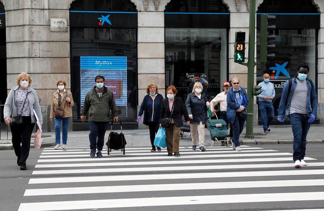 Varias personas con mascarilla cruzan la calle Jesús de Monasterio en Santander. / J. R.