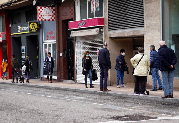 Varias personas junto a comercios cerrados en la calle Vargas, Santander. / J.R.