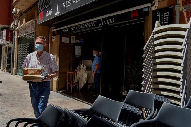 Un cliente después de recoger un pedido de comida para llevar de un restaurante del centro de Lleida. EFE/Ramón Gabriel