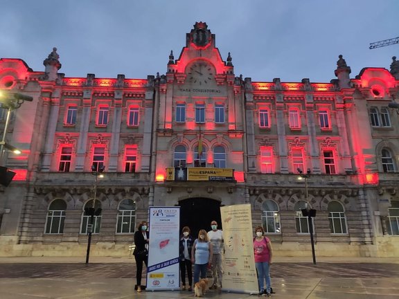 Fachada del Ayuntamiento de Santander iluminada de rojo ayer.