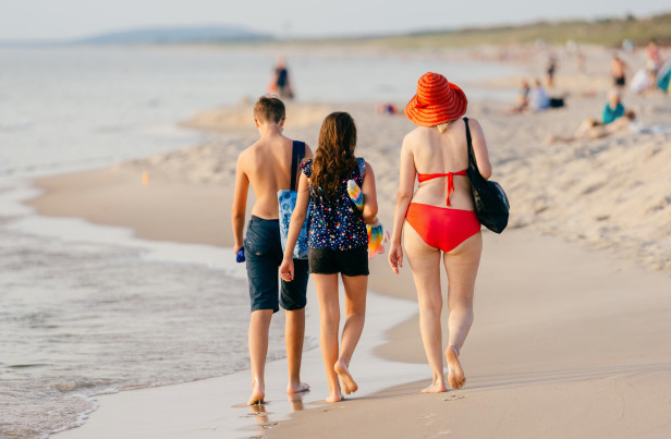 Tres personas camina por una playa. / ALERTA