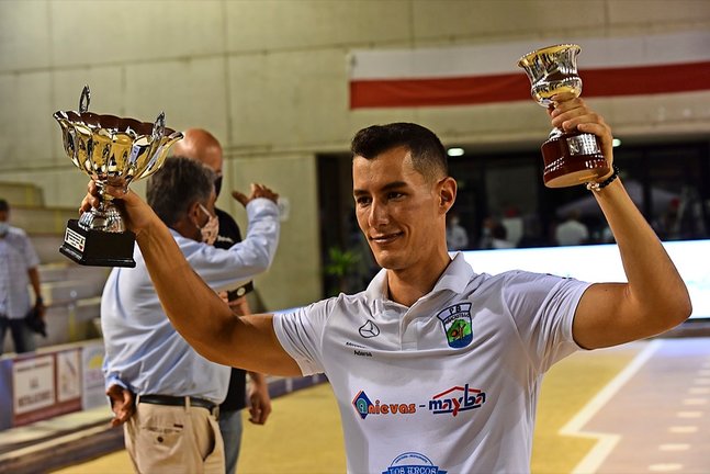 Víctor González levanta los trofeos que le acreditan como campeón regional de Primera categoría 2020. / reguera