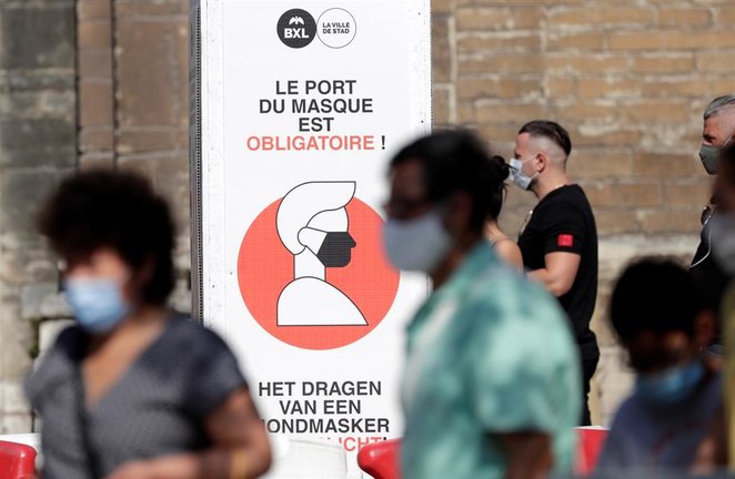 La gente camina junto a un letrero que informa que debe usar máscaras faciales en Bruselas, Bélgica, 12 de agosto de 2020.EFE / EPA / OLIVIER HOSLET