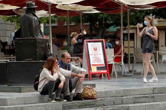 Una pareja de turistas fuman sentados en una plaza del centro de Oviedo. EFE/Alberto Morante