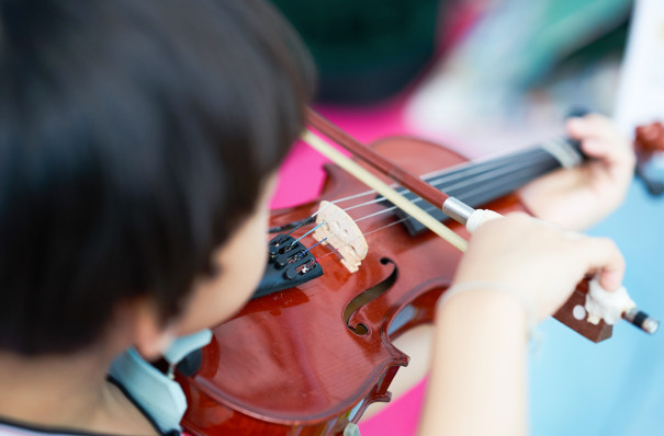 Un niño toca un violín.