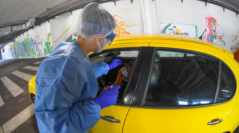 Un técnico sanitario realiza el test PCR en el parking en Santander. / HARDY