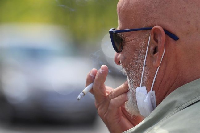Un hombre se fuma un cigarrillo este jueves en Madrid. La prohibición de fumar en la calle y en las terrazas si no se cumple una distancia interpersonal de 2 metros entra en vigor este jueves en Madrid, junto con otras restricciones para evitar contagios del virus, como adelantar el cierre de bares a restaurantes a la 1.00. EFE/Fernando Alvarado