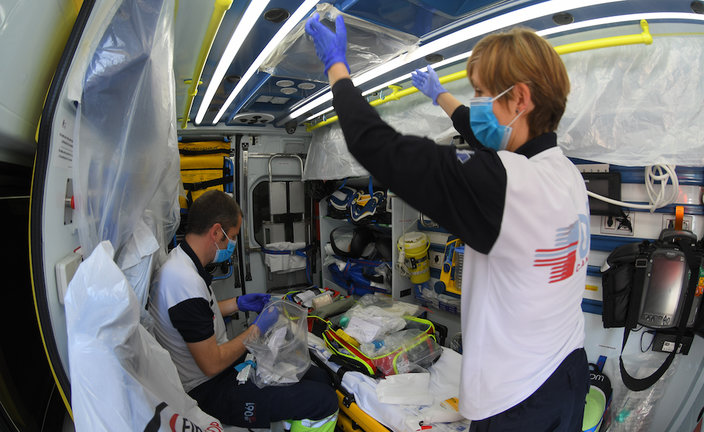Unos técnicos sanitarios en la ambulancia preparándola para el traslado de un paciente. / HARDY