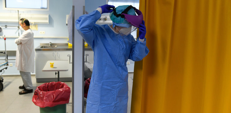 Un sanitario se coloca la máscara protectora en la zona UCI del Hospital Marqués de Valdecilla. / ALERTA