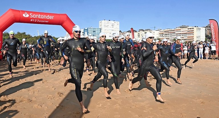 Salida de los participantes en la Segunda Playa del Sardinero, corriendo hacia el agua para realizar el sector de natación. / Hardy