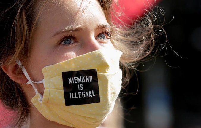 Activista de derechos humanos con `` nadie es ilegal &#39;&#39; en su máscara protesta frente al Parlamento Europeo.