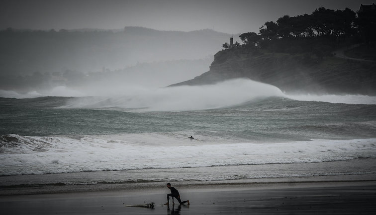 Un surfista en el Sardinero se prepara para hacer deporte en un día en que el temporal Álex ha dejado fuertes vientos e importantes lluvias. / HARDY