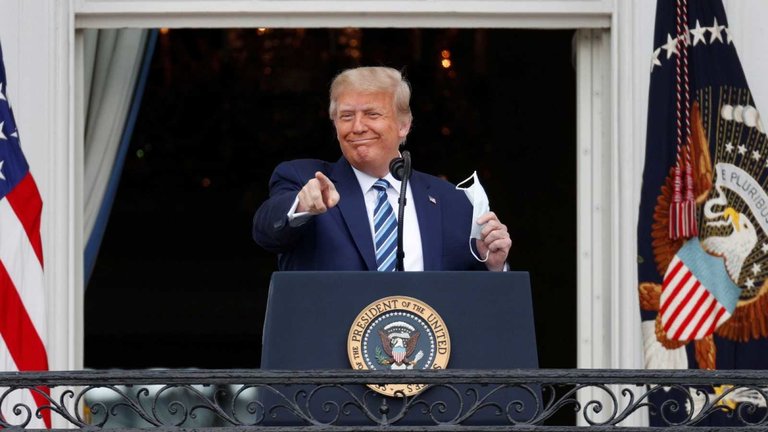 El presidente de los Estados Unidos, Donald Trump, saluda al llegar para hablar desde el Balcón Truman de la Casa Blanca en Washington. EFE/EPA/Erin Scott